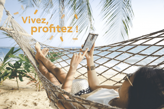 Une personne est en vacances sur un hamac et est tranquille d'esprit grâce à l'application mobile OtioHome qu'elle consulte depuis la plage pour veiller sur sa maison
